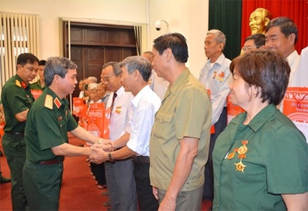 Lt. Gen. Do Can (L) presenting gifts to national contributors from Dong Nai province