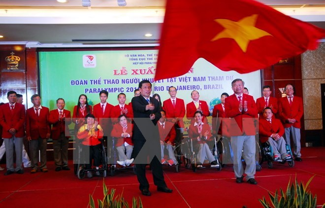 Minister of Culture, Sports, and Tourism Nguyen Ngoc Thien presents the national flag to the Paralympics delegation (Photo: VNA)