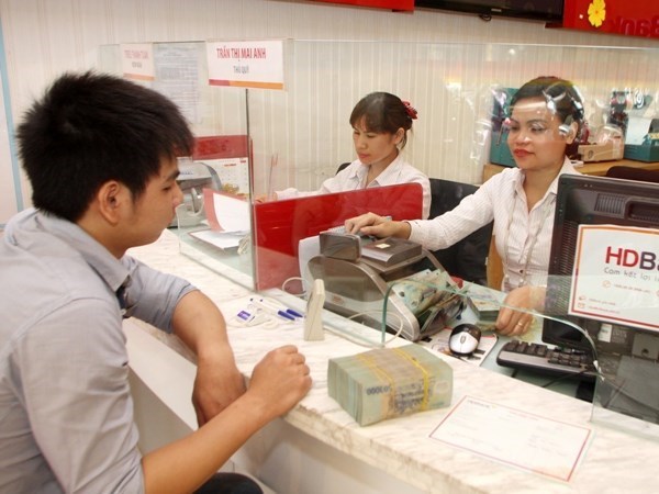 A transaction at a bank. Illustrative image (Photo: VNA)