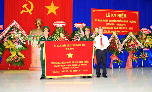 Ông Huỳnh Văn Tịnh, Giám đốc Sở Lao động - thương binh và xã hội trao bức trướng của UBND tỉnh cho Trường cao đẳng nghề số 8.