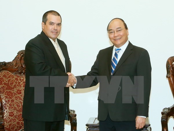 Prime Minister Nguyen Xuan Phuc (R) receives Prensa Latina President Luis Enrique Gonzalez Acosta on October 27