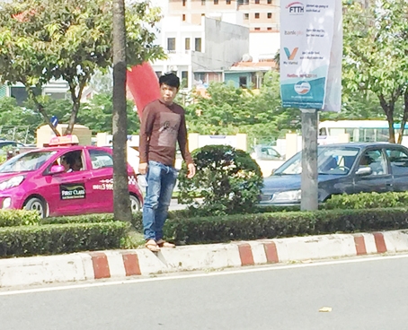 Có người bất chấp nguy hiểm nên đi qua dải phân cách để sang đường vào Bệnh viện đa khoa Đồng Nai. (Ảnh: Kim Liễu)