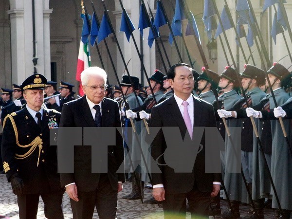 President Tran Dai Quang (R) and his Italian counterpart Sergio Mattarella inspect the guard of honour 