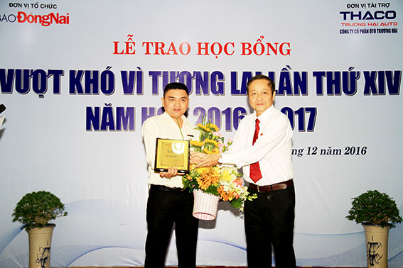 Tổng biên tập Báo Đồng Nai Trần Huy Thanh trao hoa và quà  cho đại diện nhà tài trợ Công ty cổ phần ô tô Trường Hải 