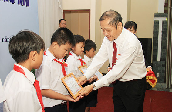 Tổng biên tập Báo Đồng Nai Trần Huy Thanh trao học bổng cho các em học sinh (Ảnh: Công Nghĩa)