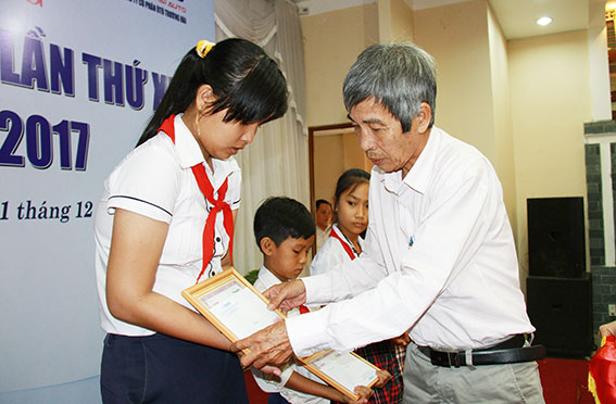 Phó chủ tịch Hội Nhà báo tỉnh Đỗ Trung Tiến trao học bổng cho các em học sinh.