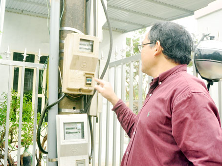 Thầy Lê Đăng Dung và hộp đồng hồ điện mà thầy đứng ra mua lại hệ thống chiếu sáng cho đường Đồi Đá.