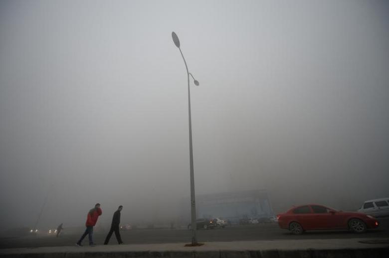  People walk in heavy smog during a polluted day in Jinan, Shandong province, China, December 20, 2016.