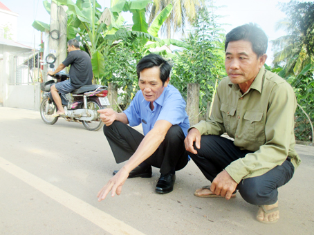 Hai cựu chiến binh Phạm Xuân Thế (trái) và Phạm Thanh Bình bên đoạn đường liên tổ 1-2 vừa tráng nhựa và lắp đặt hệ thống nước sạch dưới tim đường.