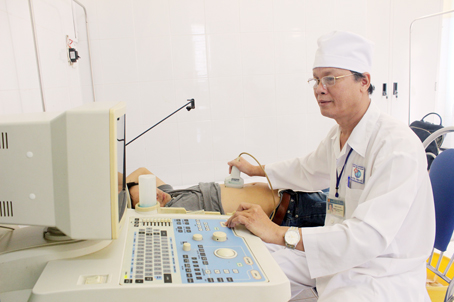 Bác sĩ Trịnh Văn Phúc, Trưởng phòng khám đa khoa xã Phú Lý (huyện Vĩnh Cửu) siêu âm cho bệnh nhân.