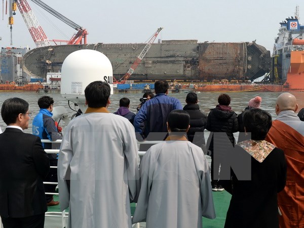 Thân nhân các nạn nhân trong vụ chìm phà Sewol theo dõi quá trình trục vớt ở ngoài khơi đảo Jindo, Hàn Quốc ngày 28/3. (Nguồn: EPA/TTXVN)