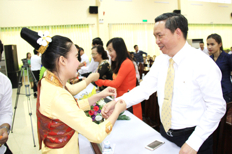 Du học sinh Lào thực hiện nghi thức buộc chỉ cổ tay cho Phó chủ tịch HĐND tỉnh Phạm Ngọc Tuấn. Ảnh: C.Nghĩa
