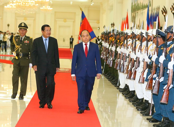 Prime Minister Nguyen Xuan Phuc (R) and his Cambodian counterpart Samdech Techo Hun Sen review the honour guard at the welcome ceremony for the Vietnamese leader on April 25