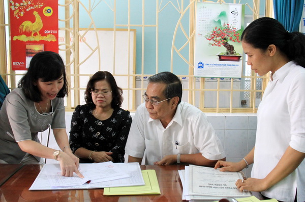 Đồng chí Phó bí thư Tỉnh ủy Trần Văn Tư và Phó chủ tịch UBND tỉnh Nguyễn Hòa Hiệp kiểm tra việc ghi chép sổ nhập và phát sữa cho học sinh. 