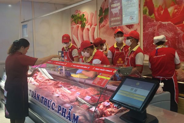 A consumer looks at pork on sale at a supermarket in HCMC. Dong Nai Province is asking HCMC to help consume some 10,000 pigs a day to cope with an oversupply - PHOTO: VU YEN