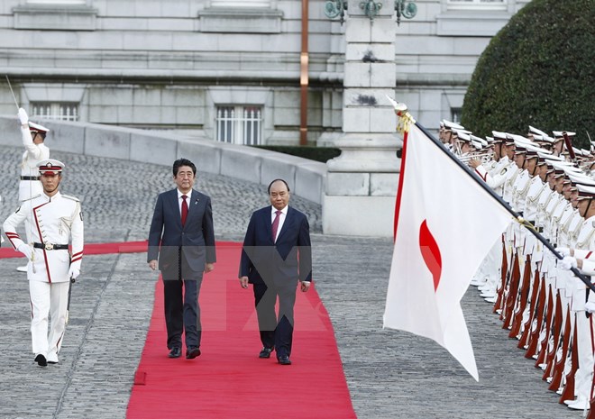 Thủ tướng Nhật Bản Shinzo Abe và Thủ tướng Nguyễn Xuân Phúc duyệt Đội danh dự tại Lễ đón chính thức. (Ảnh: Thống Nhất/TTXVN)