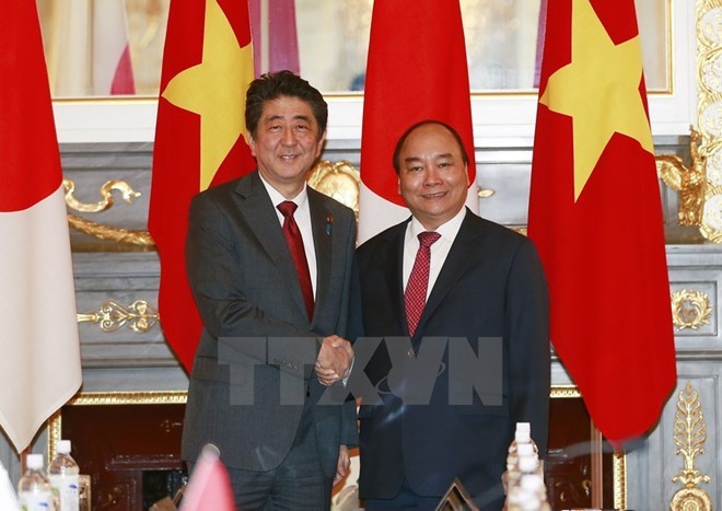 Vietnamese Prime Minister Nguyen Xuan Phuc (R) and his Japanese counterpart Shinzo Abe