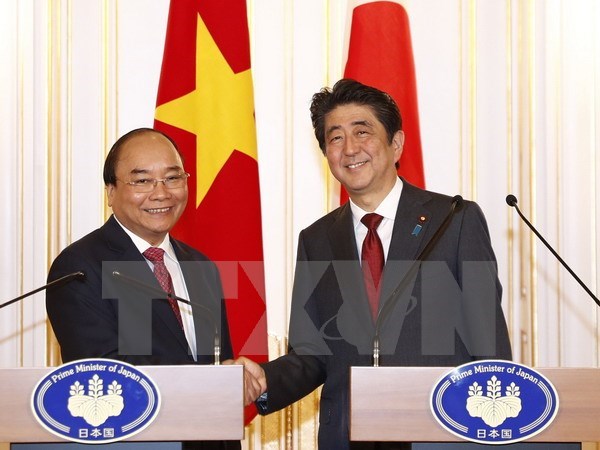 Prime Minister Nguyen Xuan Phuc (L) and his Japanese counterpart Shinzo Abe at a press conference following their talks