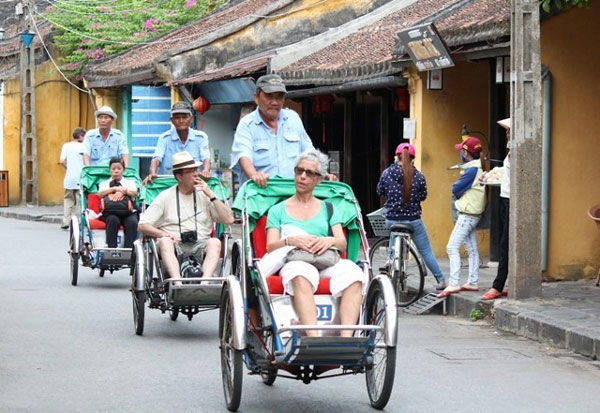 Foreigners travel around Hoi An Ancient Town in the central province of Quang Nam by Xich lo (cyclos). 