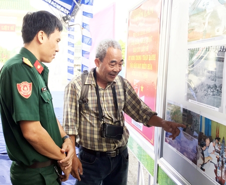 Cựu chiến binh Chế Trung Hiếu (phải), người góp phần tìm ra ngôi mộ tập thể các liệt sĩ trong trận đánh Sân bay Biên Hòa năm 1968  kể lại chặng đường đi tìm mộ liệt sĩ cho chiến sĩ trẻ tại Nghĩa trang liệt sĩ tỉnh ngày 11-7.