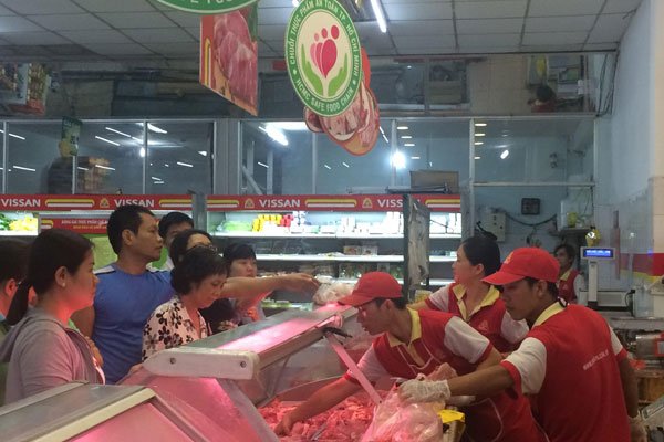 Customers buy pork at a retail store - PHOTO: TTXVN