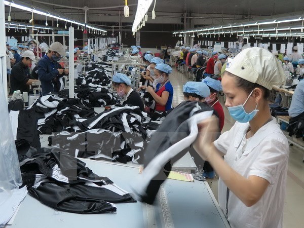 Workers make cloths for export at a factory in Vietnam (Photo: VNA)