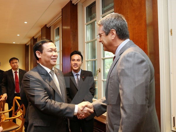 Deputy PM Vuong Dinh Hue shakes hands with WTO Director-General Roberto Azevedo in a meeting in Geneva on September 15. (Photo: VNA)