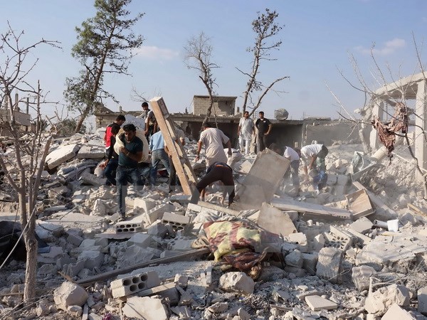 Tìm kiếm các nạn nhân dưói những đống đổ nát sau vụ không kích tại tỉnh Idlib ngày 20/9. (Nguồn: AFP/TTXVN)