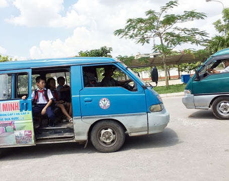 Xe đang chạy nhưng cửa vẫn mở và học sinh ngồi chênh vênh trên xe tại Trường tiểu học Long Bình Tân (TP.Biên Hòa). Ảnh: M.QUÂN