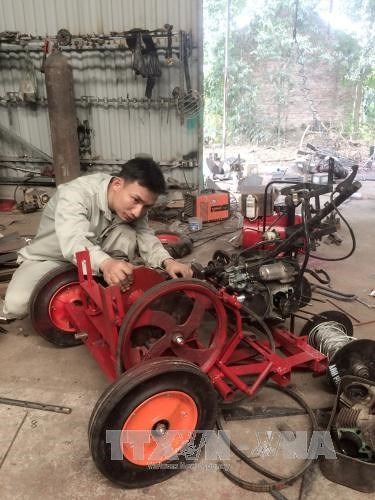 Tạ Đình Huy works at his mechanic workshop.