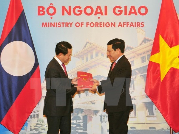 Deputy Prime Minister and Foreign Minister Pham Binh Minh (R) and Lao Foreign Minister Saleumxay Kommasith 