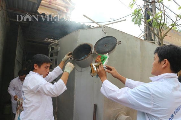 Tao Nguyen Giap (left) and a group member put rubbish into the machine for burning.