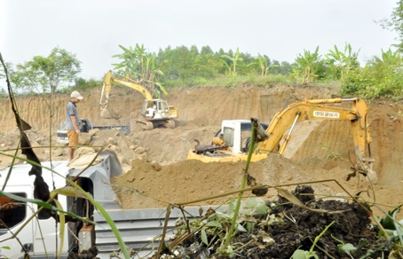 Máy cuốc múc đất đưa lên xe chở đi tiêu thụ tại một điểm khai thác đất trái phép ở ấp Hưng Bình (xã Hưng Thịnh, huyện Trảng Bom).