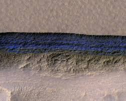 A cross-section of a thick sheet of underground ice is exposed at the steep slope that appears bright blue in this enhanced-color view of Mars from the High Resolution Imaging Science Experiment (HiRISE) camera on NASA's Mars Reconnaissance Orbiter in this image released on January 11, 2018.