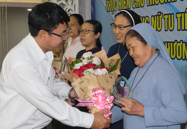 Phó trưởng ban Dân vận Tỉnh ủy Nguyễn Văn Khang tặng hoa chúc mừng các nữ tu được biểu dương tại hội nghị