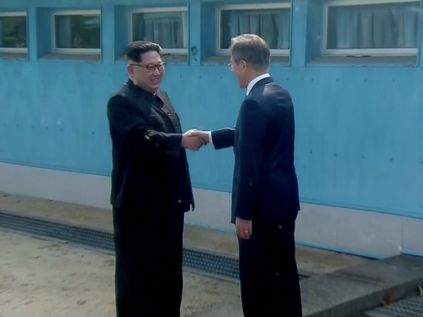 Tổng thống Moon Jae-in và lãnh đạo Kim Jong-un đã bắt tay nhau tại đường ranh giới phân định hai miền. (Nguồn: CNN)