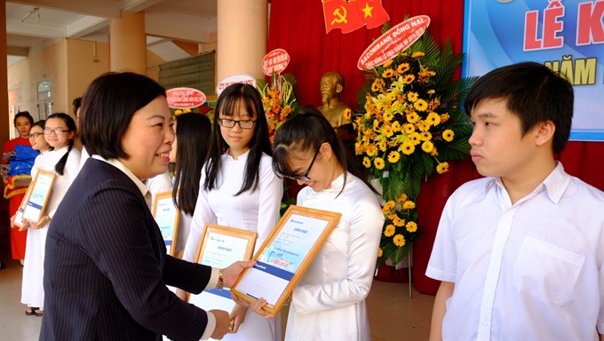 Phạm Thị Thu, director of Sacombank’s Đồng Nai branch, gives away scholarships to school students at the province’s Ngô Quyền High School. 