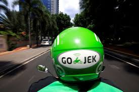 A Go-Jek driver rides a motorcycle on a street in Jakarta, Indonesia, December 15, 2017.