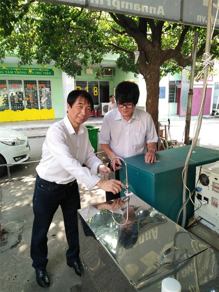 Magic device: Associate Professor Le Van Lu (left), one of the researchers, gets water from the device.