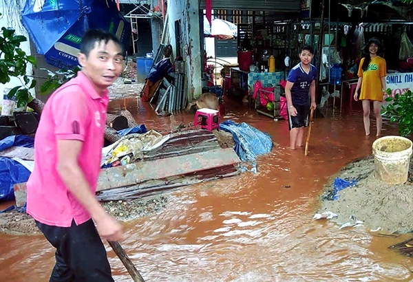 Một gia đình ở ấp Trần Hưng Đạo, xã Xuân Thạnh đang tát nước, dọn dẹp nhà cửa bị nước mưa ngập vào chiều 7-9 (ảnh phải). Các phương tiện rất khó khăn mới qua được đoạn ngập trên quốc lộ 1 chiều 7-9.