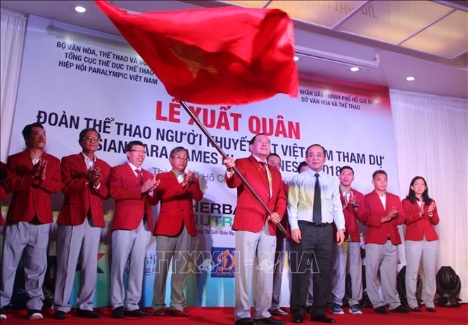 Trong ảnh: Đại diện Bộ Văn hóa và Thể thao trao cờ xuất quân cho đoàn thể thao người khuyết tật Việt Nam. Ảnh: Xuân Dự - TTXVN