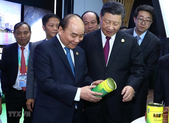 Prime Minister Nguyen Xuan Phuc  (front, left) and Party General Secretary and President of China Xi Jinping (front, right) visit the Vietnamese pavilion at the first China International Import Expo.