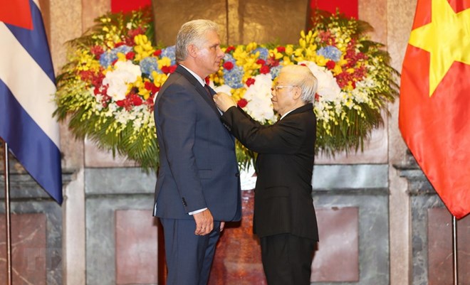 Party General Secretary and President Nguyen Phu Trong (R) bestows a Ho Chi Minh Order upon President of the Council of State and Council of Ministers of Cuba Miguel Mario Diaz-Canel Bermudez in recognition of his contributions to the Vietnam-Cuba friendship and cooperation