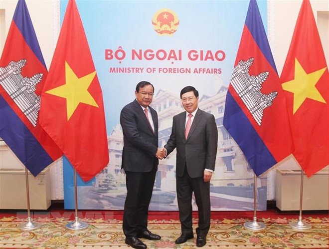 Deputy PM and FM Pham Binh Minh (R) shakes hands with Deputy PM and Minister for Foreign Affairs and International Cooperation of Cambodia Prak Sokhonn