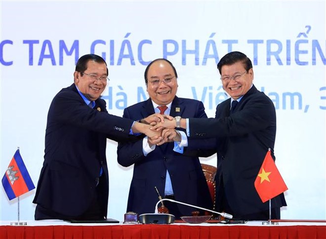 The three Prime Ministers of Cambodia, Laos and Vietnam show solidarity and cooperation spirit after the signing of a Joint Declaration of the 10th Cambodia-Laos-Vietnam (CLV-10) Development Triangle Summit (CLV-10). (Photo: VNA)
