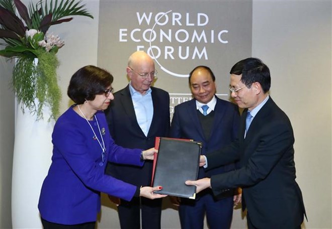 PM Nguyen Xuan Phuc (blue tie) and WEF Founder and Executive Chairman Klaus Schwab witness the signing of  an agreement between the WEF and Vietnam on building a centre for the Fourth Industrial Revolution. 