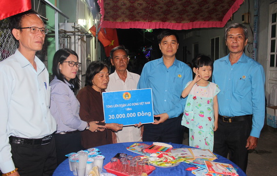 Phó chủ tịch Tổng Liên đoàn Lao động Việt Nam Ngọ Duy Hiểu (thứ 3 từ phải qua) trao số tiền 30 triệu đồng cho gia đình anh Toàn, chị Thảo. Bé Thảo Lam đứng thứ 2 từ phải qua.
