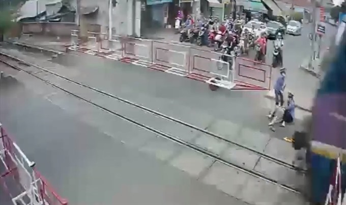 The moment two hero rail workers pull a woman to safety just seconds before a train speeds past. — Screenshot photo from CCTV.  Read more at http://vietnamnews.vn/society/505252/seconds-from-death.html#om8IYOehGXgWqfoK.99