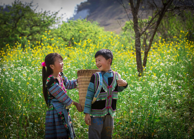 Two H'Mong ethnic children are playing on the field in Loong village, Moc Chau district, Son La province. 