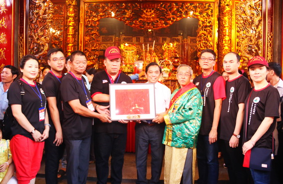 Các thành viên trong đoàn khách du lịch đến từ Trung tâm xúc tiến văn hóa Quan Công Malaysia tặng quà cho Chủ tịch Ủy Ban MTTQ Việt Nam tỉnh Huỳnh Văn Tới giữa 